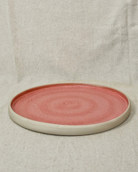 grande assiette plate en grès émaillée rose à l'intérieur et brute à l'extérieur vue de face